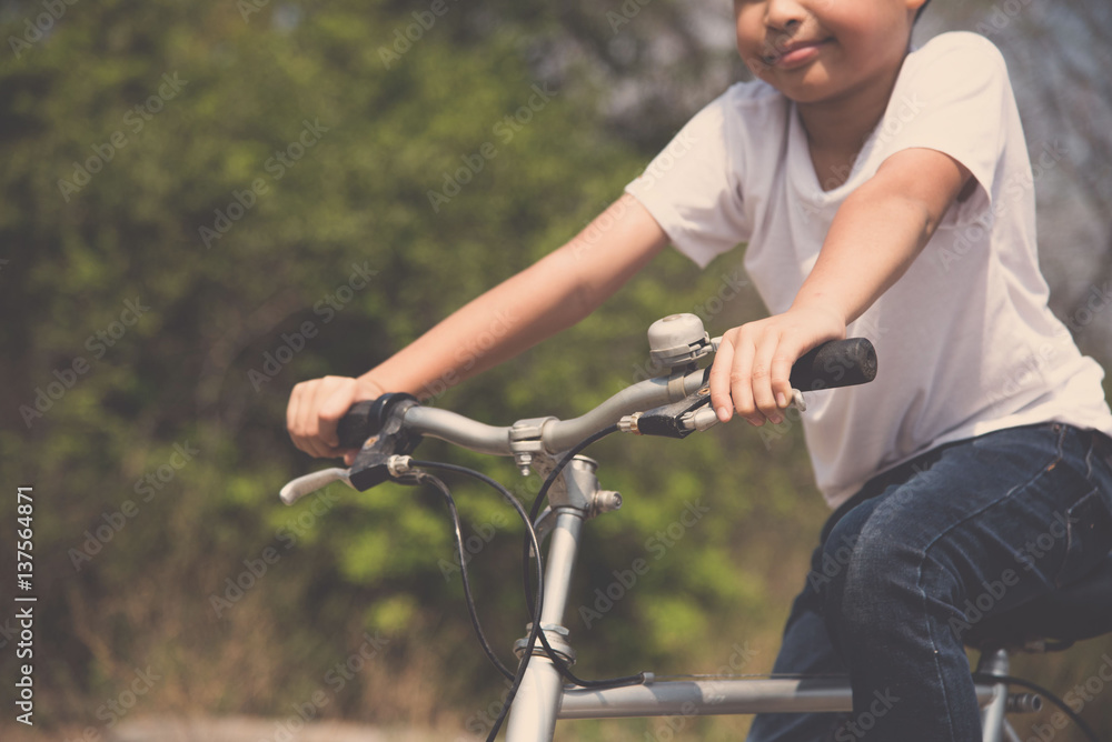 Fototapeta premium Little boy ride bicycle on the rock road.