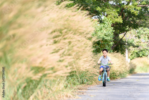 Boy riding bicycle on the road. © TinPong
