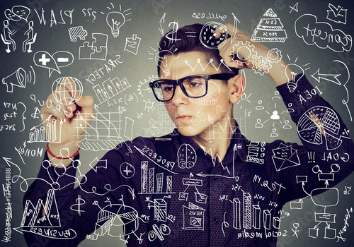 Smart thoughtful guy writing maths and science formulas on blackboard photo