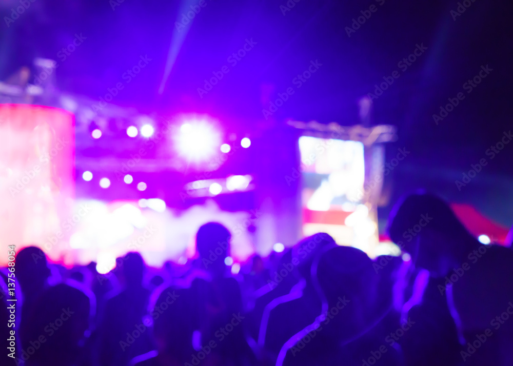 Obraz premium Blurred Youth Music Festival of pop music. Laser show on the stage. The crowd of fans. Bright abstract background ideal for any design. Blurred bokeh basic background for design 