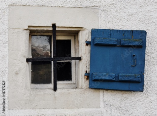 Close up of a little old window with blue wooden shutter © lehmannw