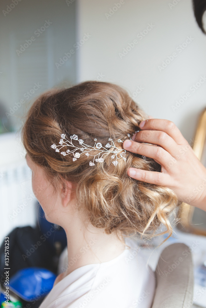 Fototapeta premium Hairdresser makes wedding hairstyle bride with blond hair