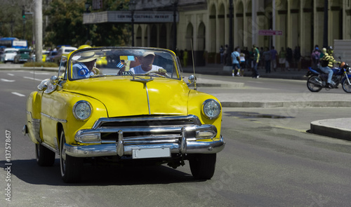 Auf der Hauptstrasse in Havanna Kuba fahrender amerikanischer gelber Cabriolet Oldtimer mit Touristen - Serie Kuba Reportage