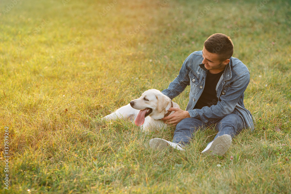 Fototapeta premium Man resting with his dog Labrador outdoors