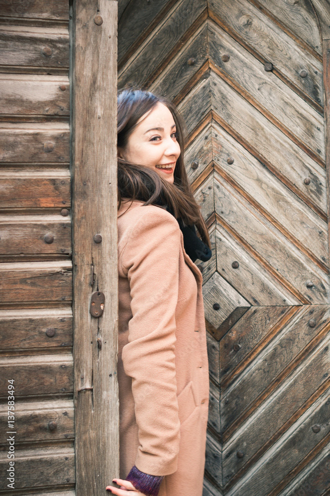beautiful girl near old wooden gate in the city beautiful girl near old wooden gate in the city
