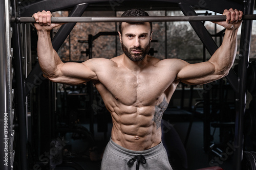 Handsome fitness model train in the gym gain muscle.