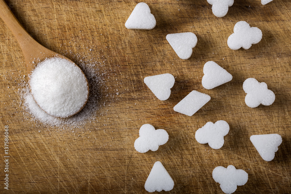Different sugar cubes shapes and wooden spoon filled with sugar Different sugar cubes shapes and wooden spoon filled with sugar