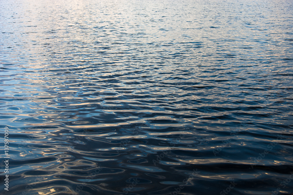 Water surface with ripples and sunrays reflections Water surface with ripples and sunrays reflections