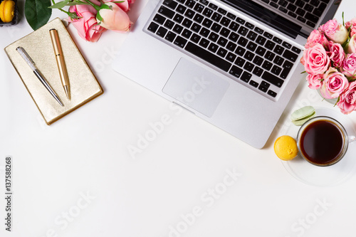 Feminine workspace border with keyboard, coffee and flowers, top view and copy space photo