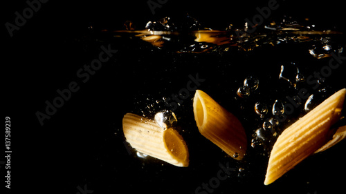 Pasta cruda splash nell'acqua della padella photo