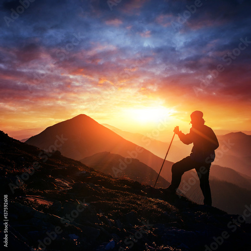 Happy man standing on a cliff at sunset © standret