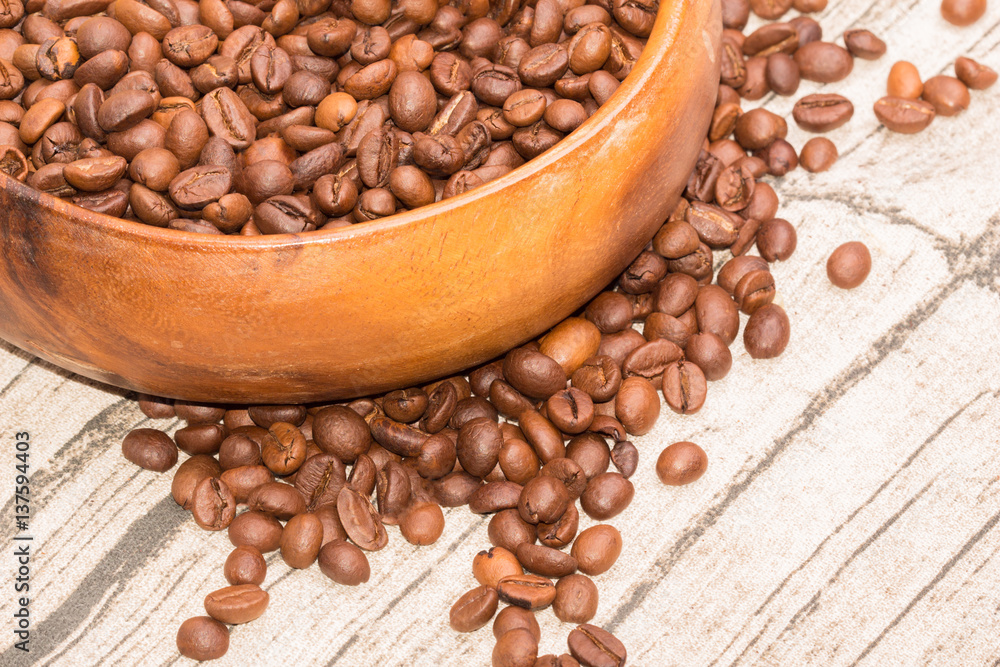 Roasted coffee beans in a wooden bowl Roasted coffee beans in a wooden bowl