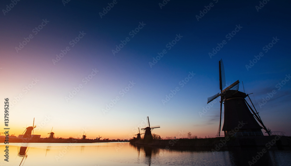 Colorful spring sunset traditional Dutch windmills canal in Rott