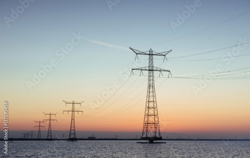Electric poles in the water at sunset