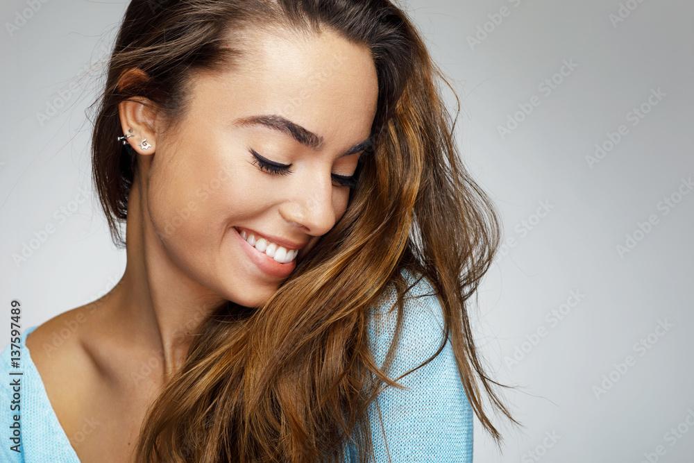 Portrait of a young woman with a beautiful smile - obrazy, fototapety, plakaty 
