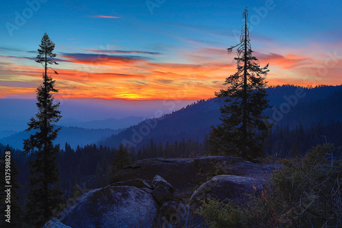 Silhouetted Trees and Granite with Blue and Orange Sunset © Quattrophotography