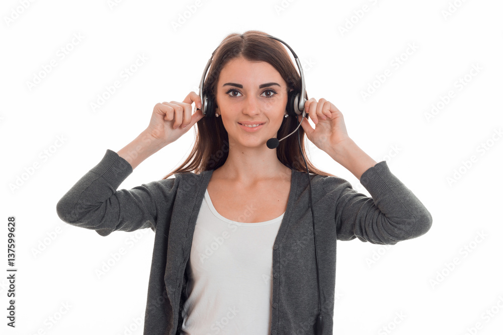 Cutie young business woman working in call center with headphones and microphone looking at the camera and smiling isolated on white background Cutie young business woman working in call center with headphones and microphone looking at the camera and smiling isolated on white background