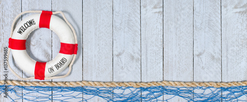 Fototapeta Welcome on Board - lifebuoy with text on horizontal wooden background texture, copy space for individual text