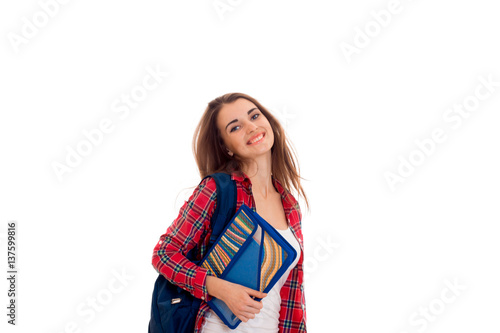Happy stylish smart student girl with backpack on her shoulders and folders for notebooks in hands posing and smiling on camera isolated on white background
