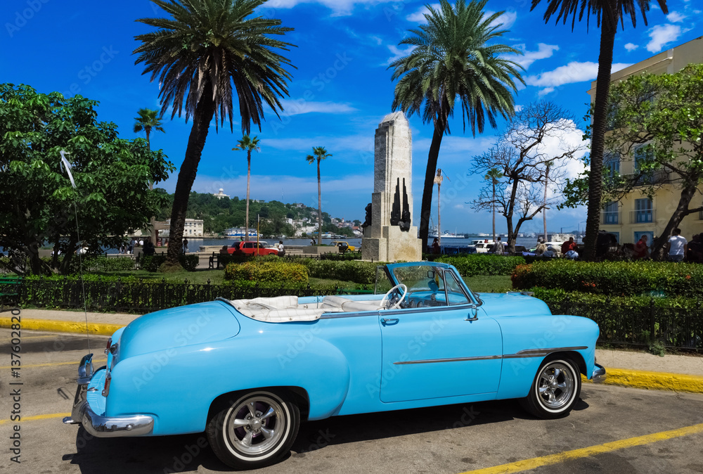 Amerikanischer blauer Cabriolet Oldtimer parkt am Malecon in Havanna Kuba unter blauem Himmel  - Serie Kuba Reportage
