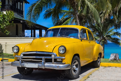 Gelber amerikanischer Oldtimer parkt unter Palmen am Strand in Varadero Kuba - Serie Kuba Reportage © mabofoto@icloud.com