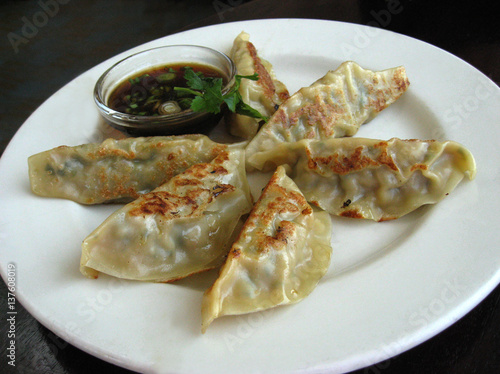 Pot stickers on a plate with hoisin sauce