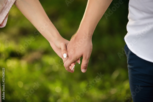 Man and woman holding hands on green background. Heterosexual couple in love © Wedding photography
