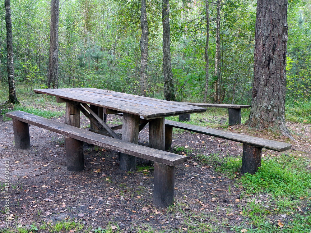 The wooden benches and the wooden table in a forest The wooden benches and the wooden table in a forest