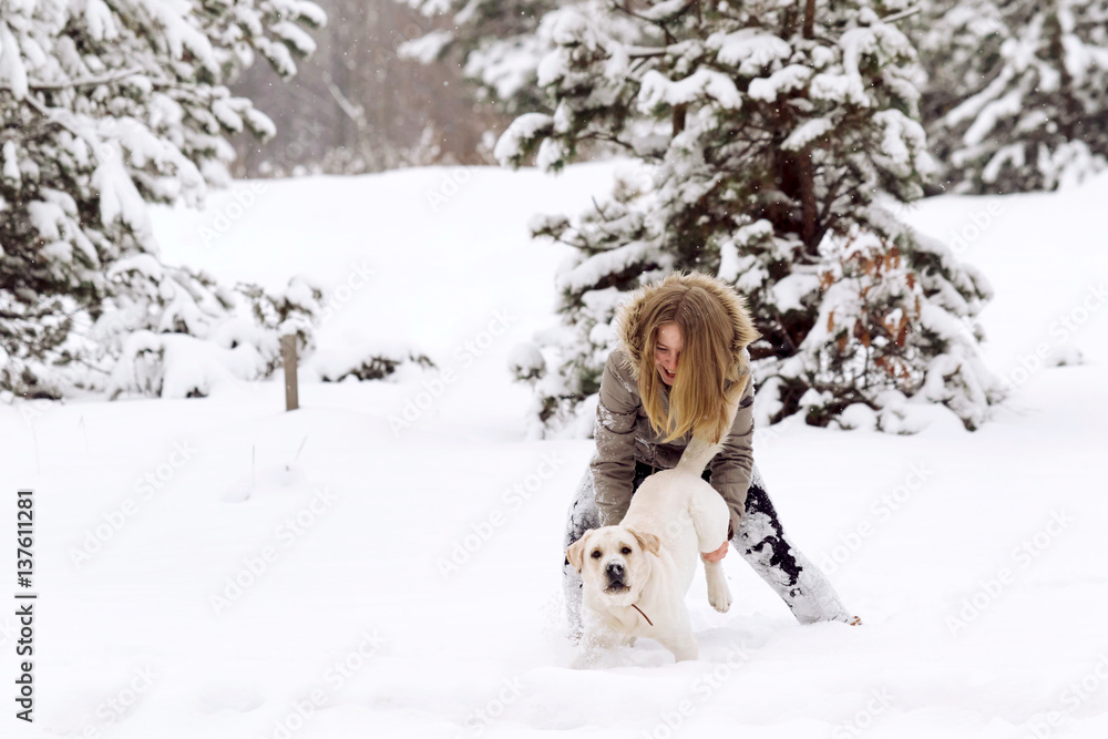 Funny girl with golden retriever labrador in winter forest. Friendship, pet and human. Funny girl with golden retriever labrador in winter forest. Friendship, pet and human.