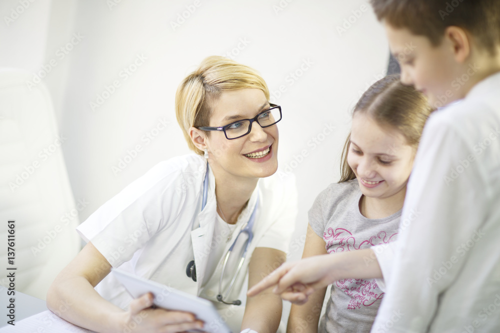 Female doctor explains diagnosis to children, using a digital tablet, Osijek, Croatai Female doctor explains diagnosis to children, using a digital tablet, Osijek, Croatai