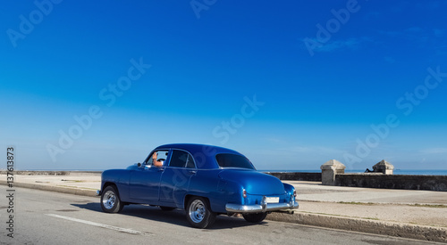 Blauer amerikanischer Oldtimer fährt auf dem Malecon im Hintergrund die karibische See in Havanna Kuba - Serie Kuba Reportage © mabofoto@icloud.com
