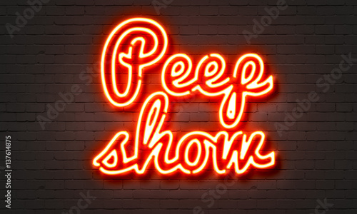 Peep show neon sign on brick wall background.