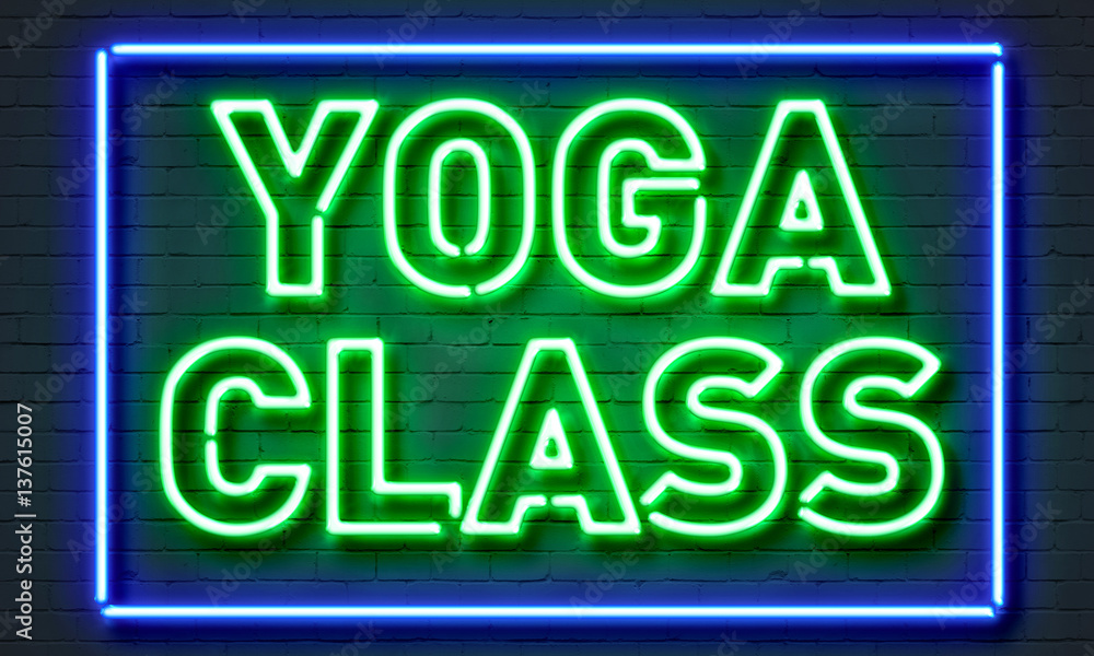Yoga class neon sign on brick wall background.