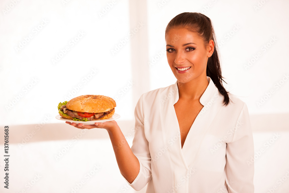 Woman eats hamburger isolated over white background Woman eats hamburger isolated over white background