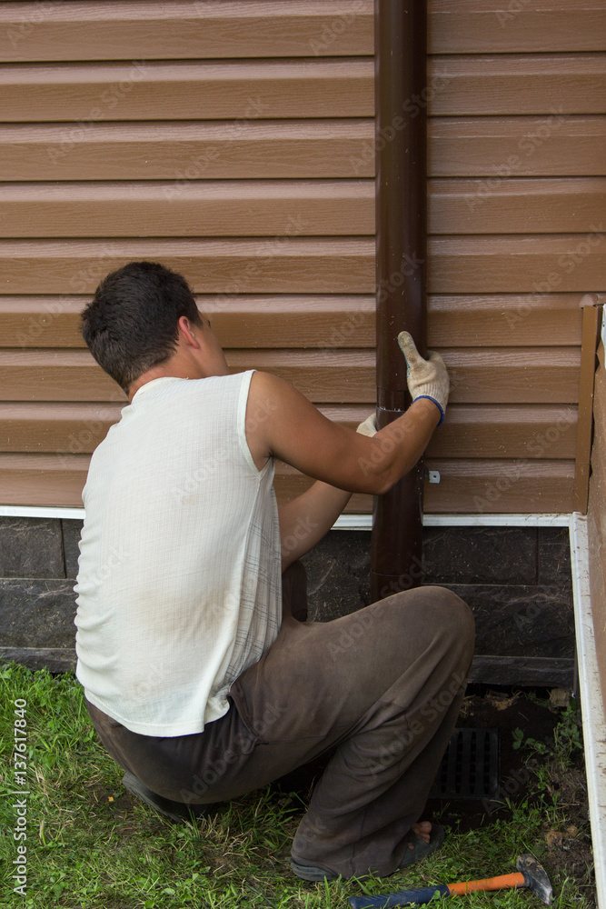 man sets drainpipe on the wall man sets drainpipe on the wall