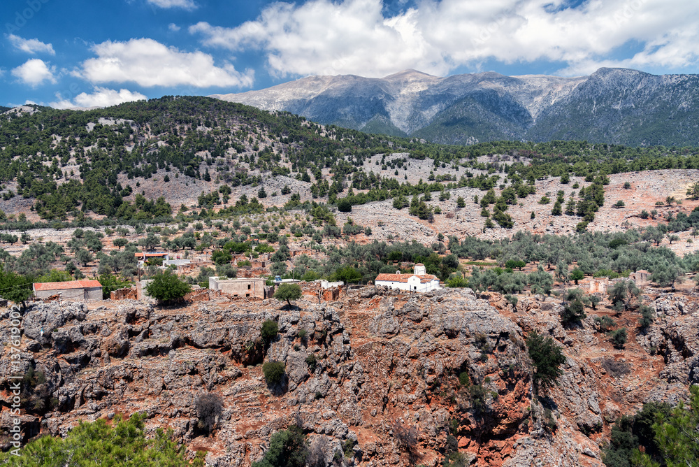 White church and ancient ruins at cliff of Aradena Gorge, Crete island, Greece
