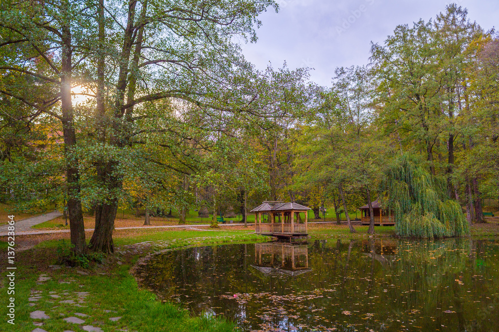 Autumn park with pond and wooden alcoves. Autumn park with pond and wooden alcoves.