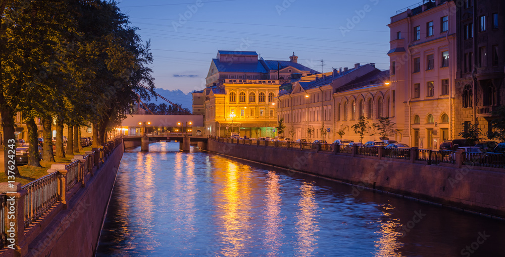 Night cityscape with river and bridge and ship in Saint-Petersburg.