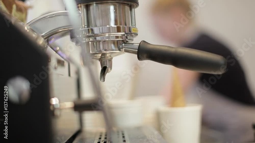 Barista making fresh coffee going out from a coffee espresso machine into a glas. Macro shot in Full HD photo