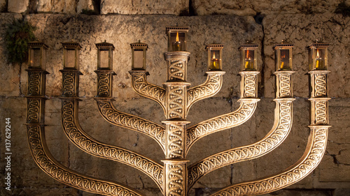 Hanukiah lit with the wailing wall in background , zoom in