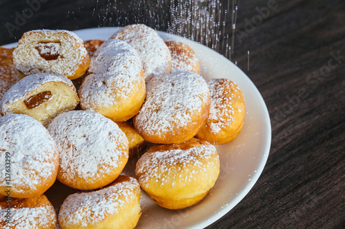 heap of marmalade filled bismarck donuts on white plate photo