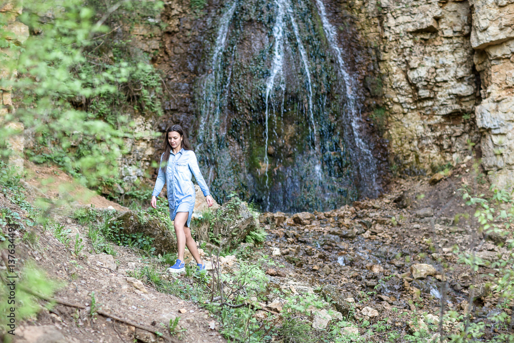 woman walking near the mountain waterfalls