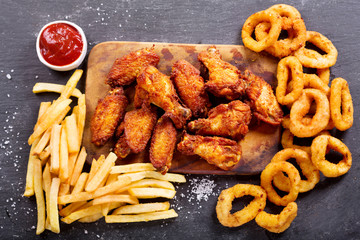 fast food meals : onion rings, french fries and fried chicken