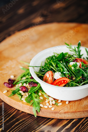 Healthy Salad with arugula, pine nuts, cranberries, tomatoes, and feta. Copy space