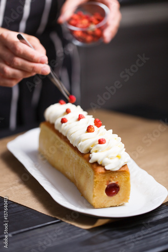 Female hands decorating cake