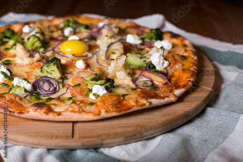 Delicious fresh homemade pizza with onions, vegetables and cheese on a wooden table. Copy space. close-up.