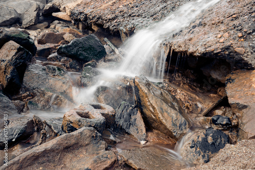 Stream Flowing Through Rocks in forest.