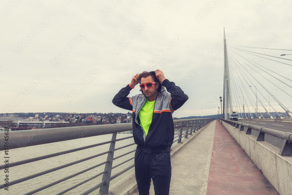 Urban jogger preparing for workout on the bridge. Urban jogger preparing for workout on the bridge.