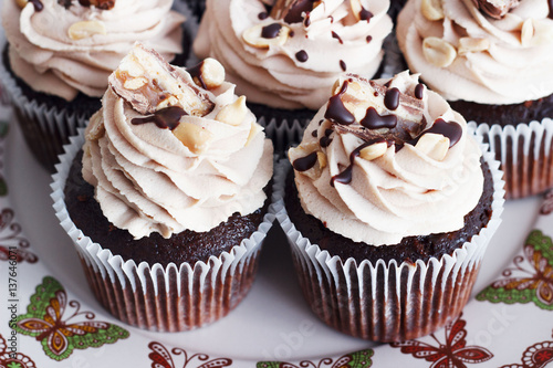 Chocolate cupcake with mousse cream icing on grunge white wooden background copy space