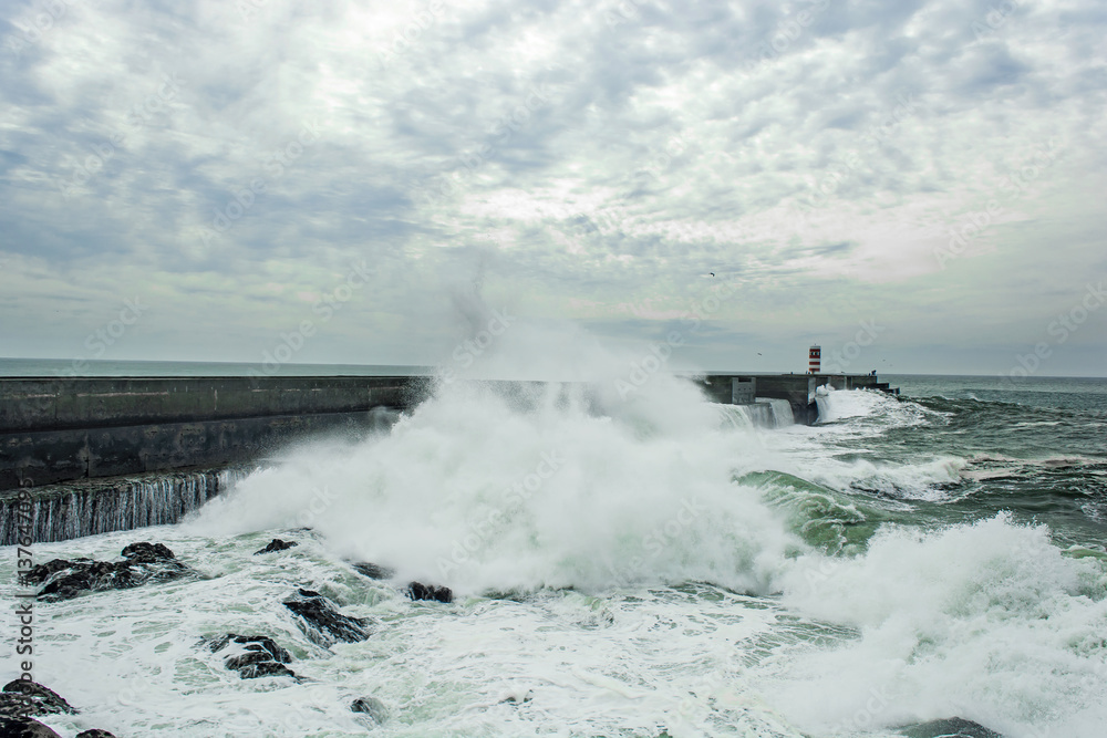 stormy sea waves crushed over pier with lighthouse in Porto, Portugal stormy sea waves crushed over pier with lighthouse in Porto, Portugal